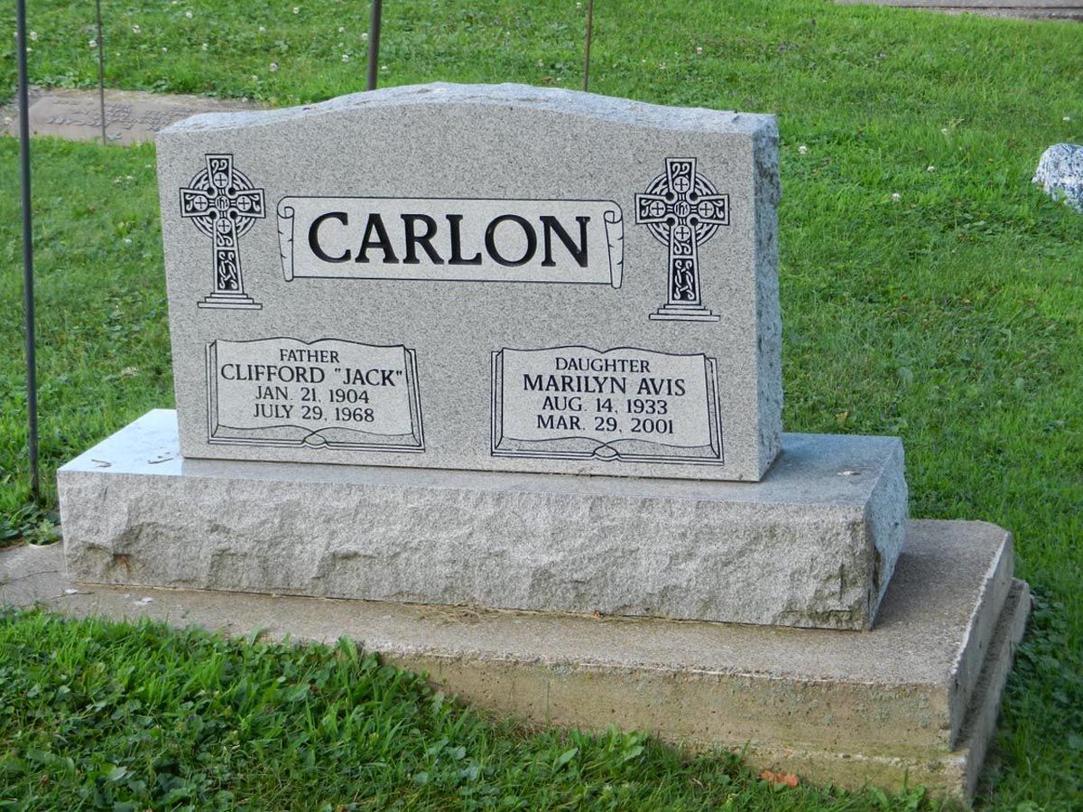 A gravestone for carlon in a cemetery with a cross on it