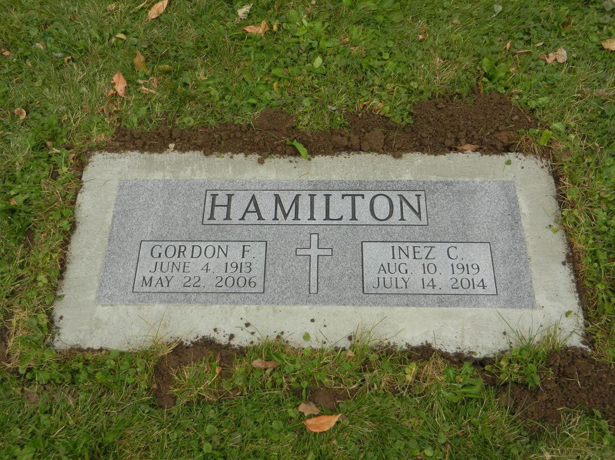 A gravestone for hamilton in a cemetery with a cross on it