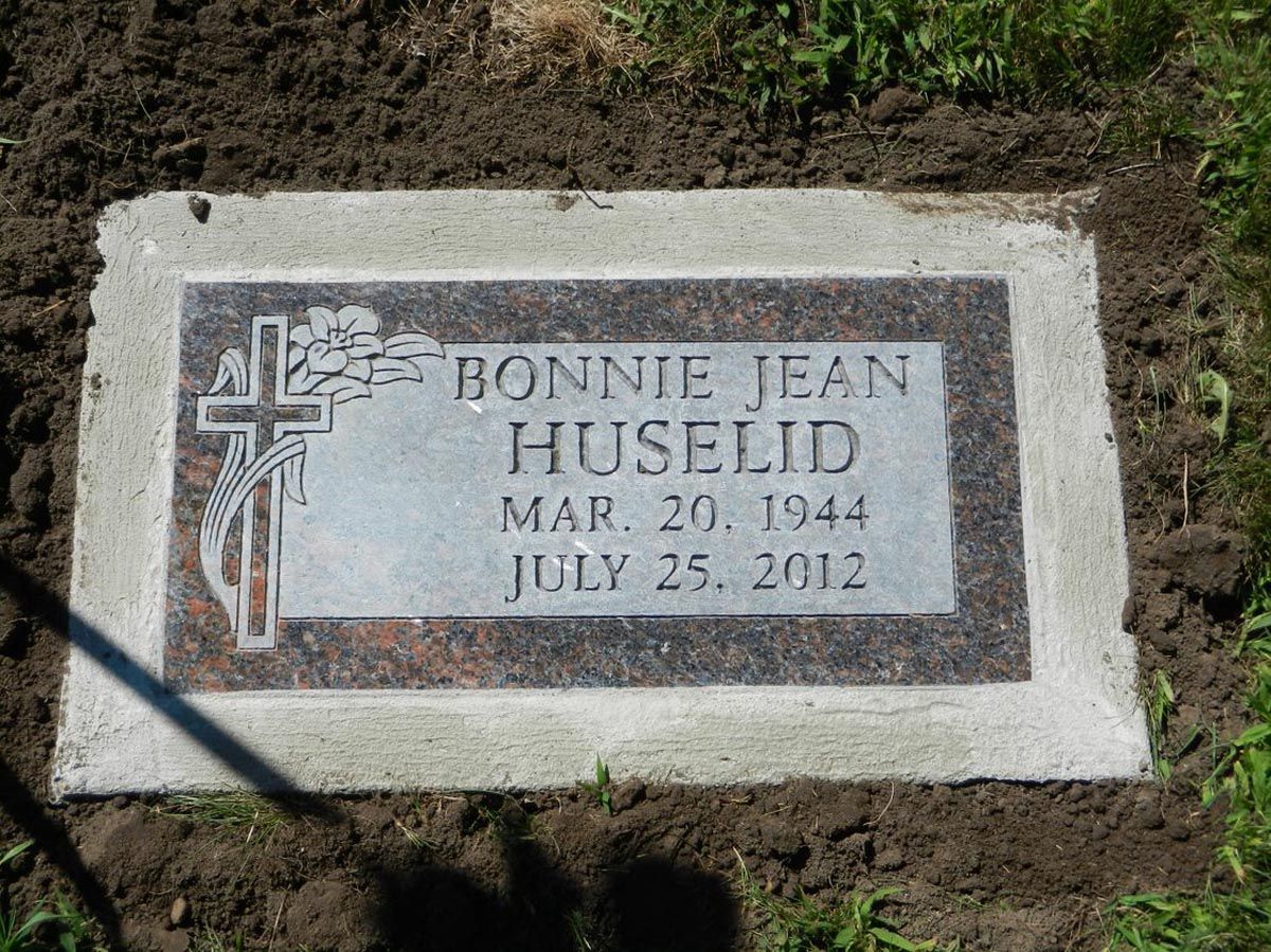 A gravestone for bonnie jean huselid is in the dirt