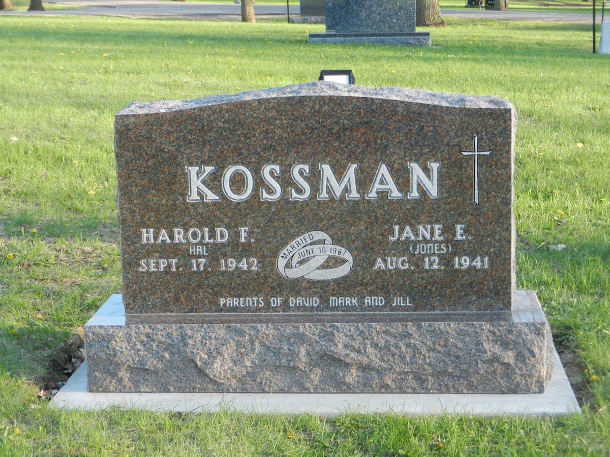 A gravestone in a cemetery with the name kossman on it