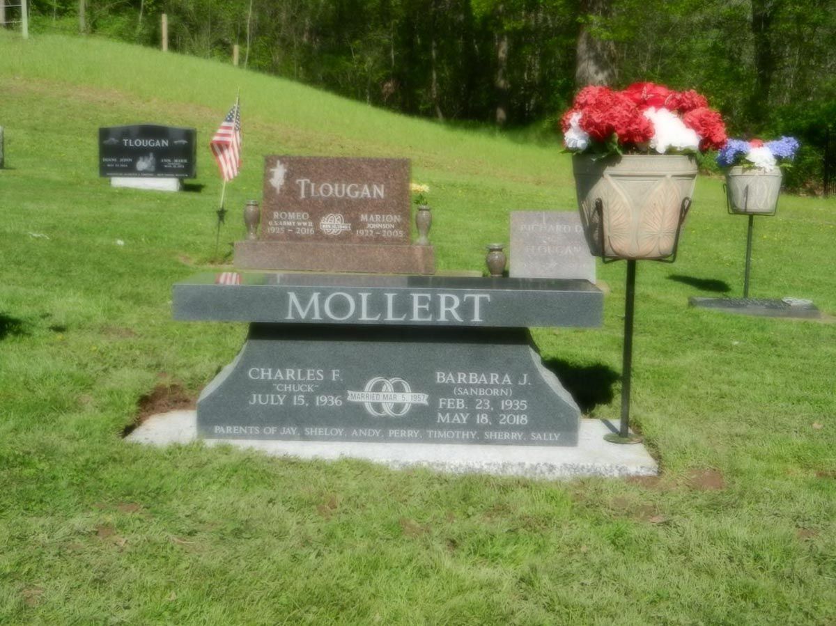 A grave in a cemetery with a bench that says mollert