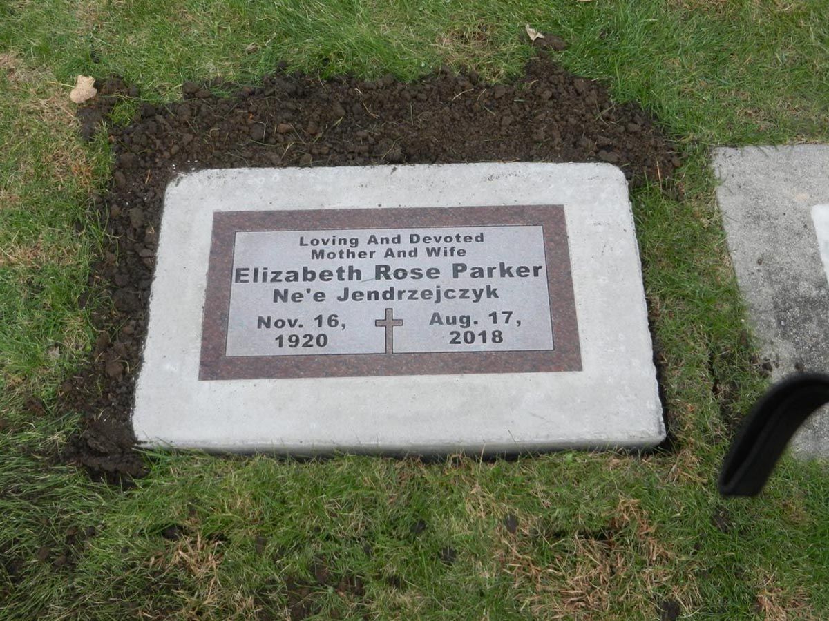 A gravestone for elizabeth rose parker sits in the grass
