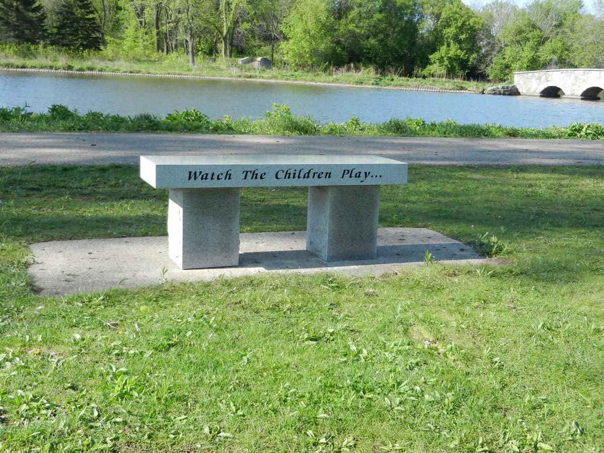 A bench in a park with a river in the background