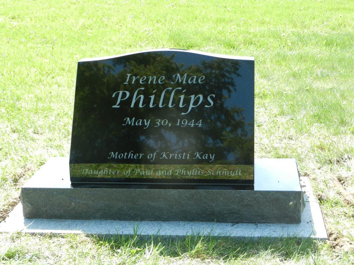 A black gravestone with the name irene mac phillips on it