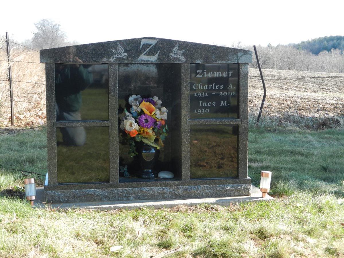 A grave with a vase of flowers in the middle of it