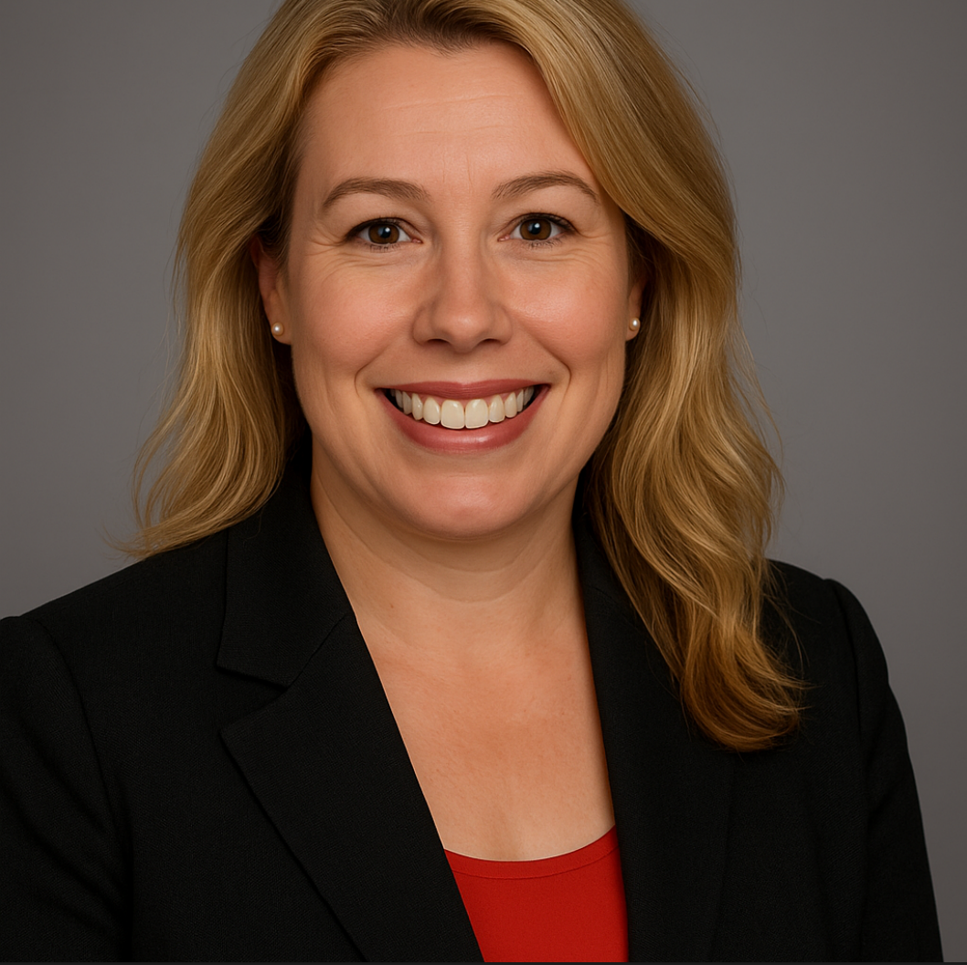 A woman wearing a black jacket and a red shirt smiles for the camera