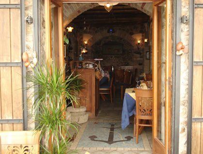 Vista da fuori dell'interno del ristorante con tavoli e sedie in legno
