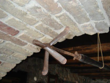 Un arpione appeso con una corda vicino a un arco di pietra sul soffitto