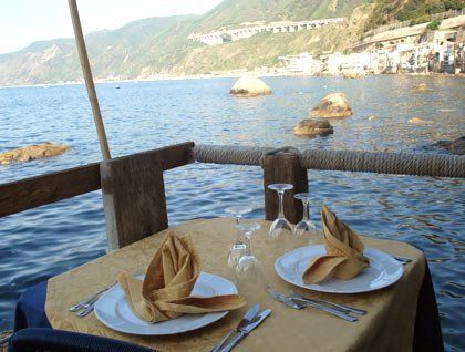 tavolo apparecchiato e vista del mare con gli scogli