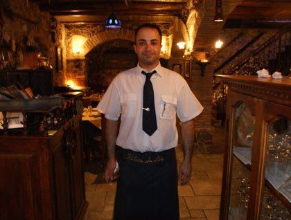Un cameriere con una camicia bianca e una cravatta nera