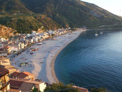 Vista dall'alto di mare, spiaggia, un paesino e delle montagne