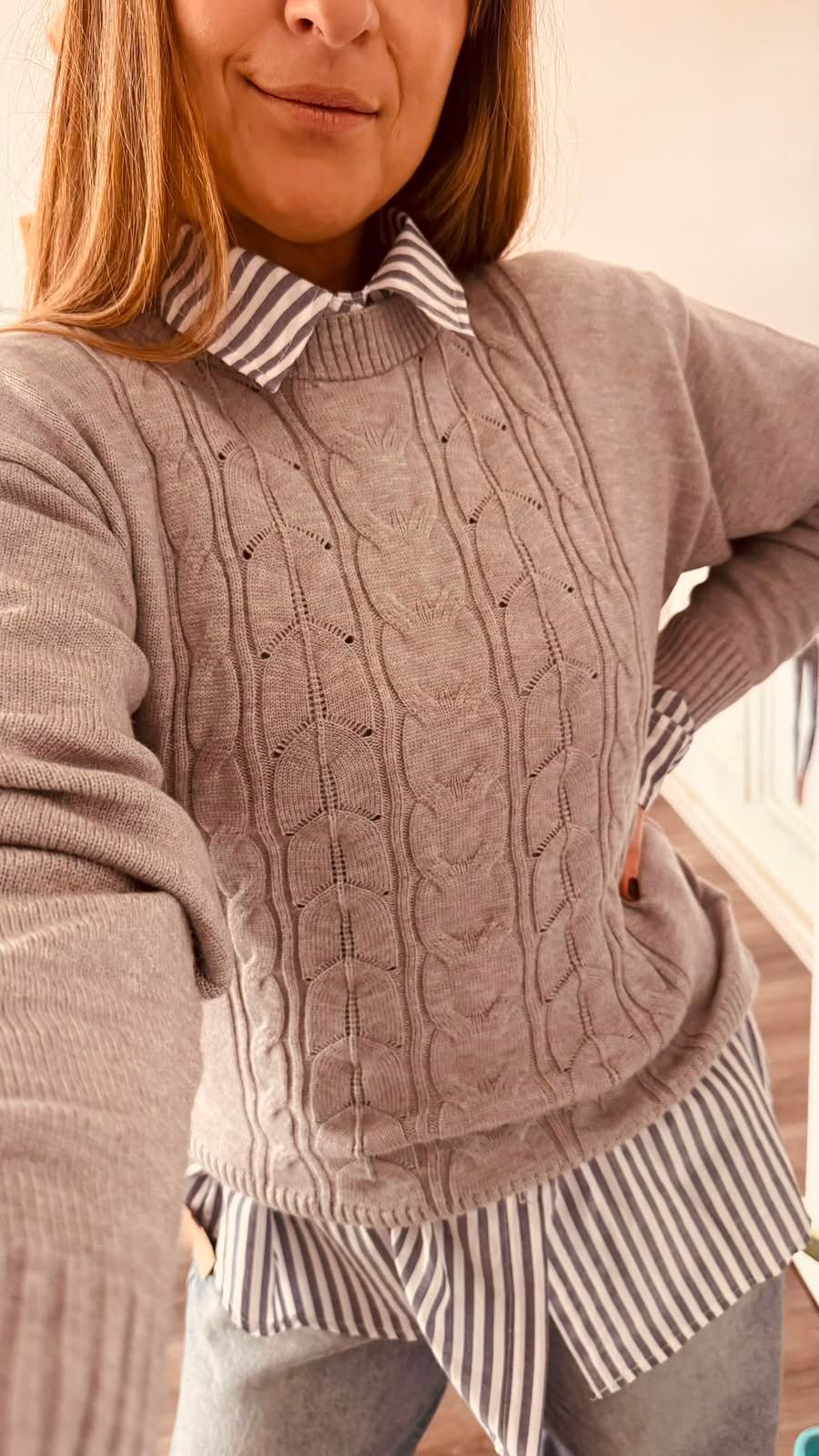 Una persona se toma una selfie frente al espejo en una tienda de ropa.