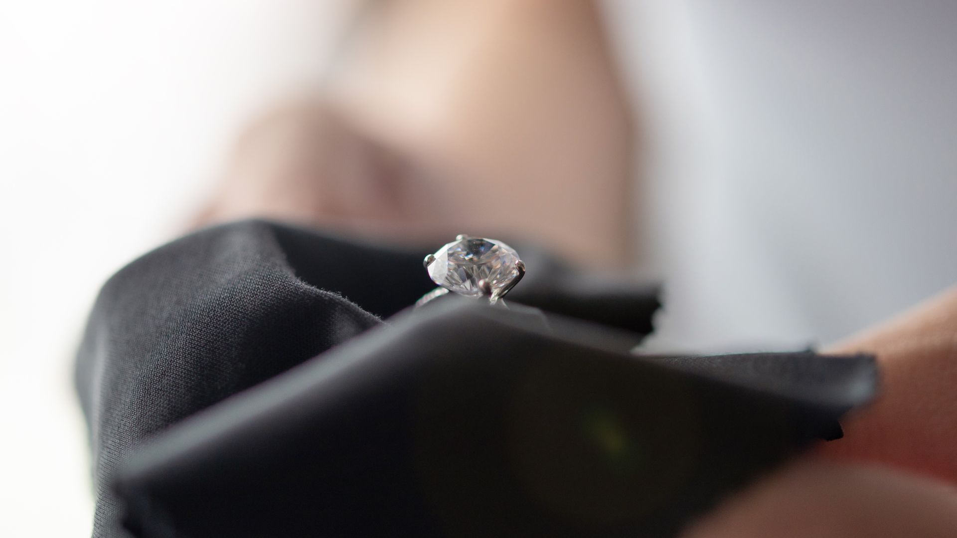 A person is holding a diamond ring in their hand.