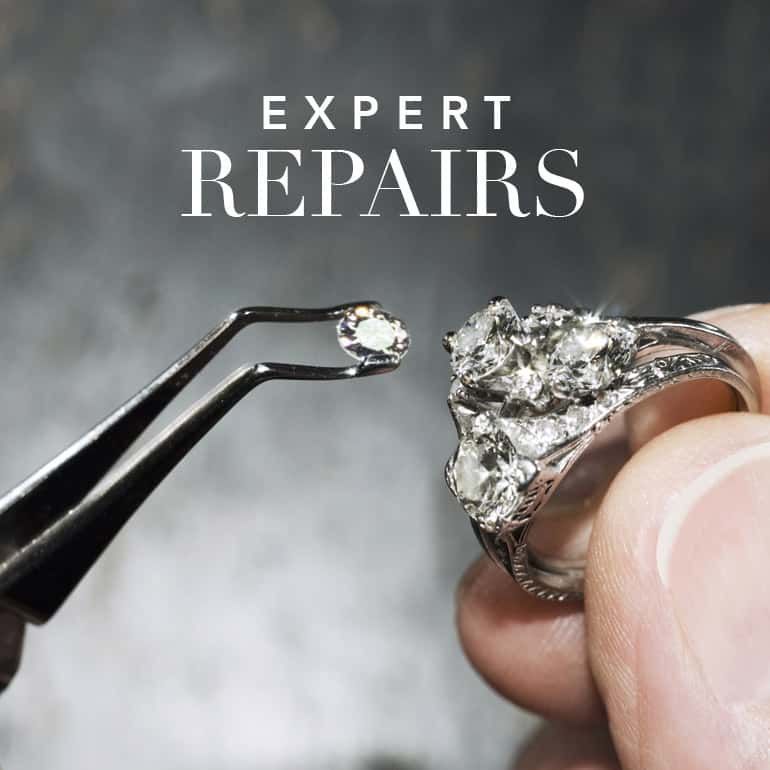 A person is repairing a diamond ring with tweezers.