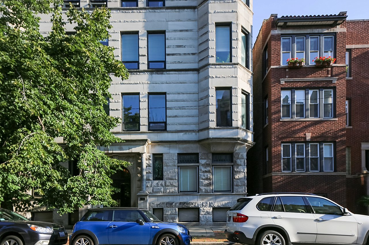 A blue car is parked in front of a building