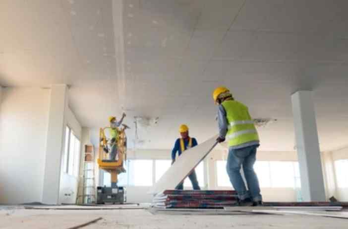 A group of construction workers are working on a building.