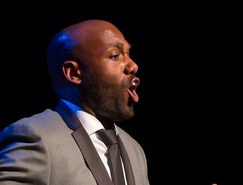 Bass singer signing and gesturing and wearing formal attire