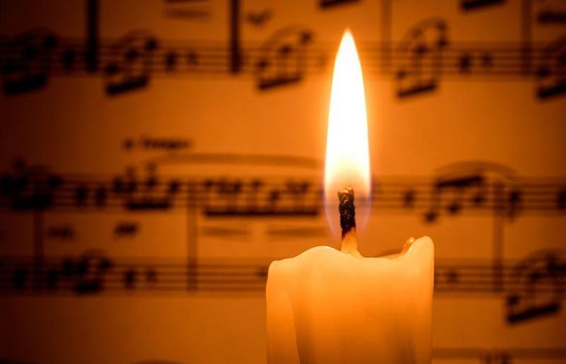 Candle with music behind it.