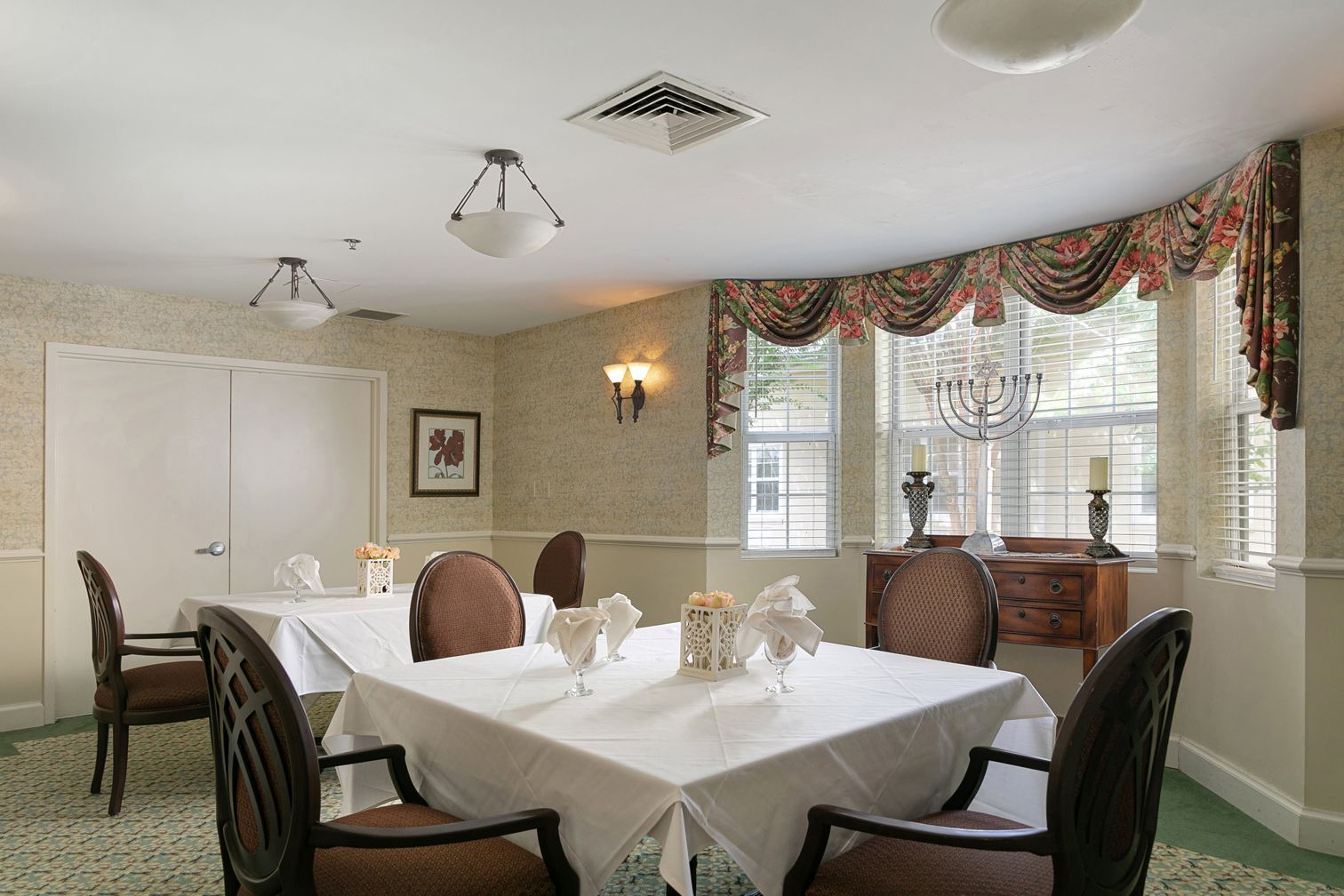 A dining room with tables and chairs and a chandelier