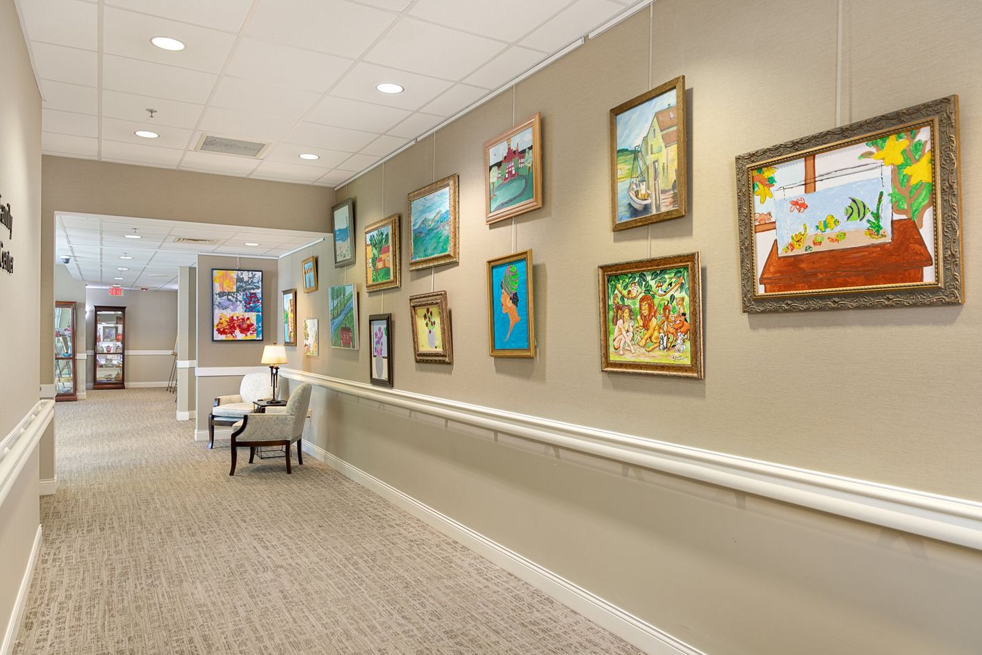 A hallway with a lot of paintings hanging on the wall.
