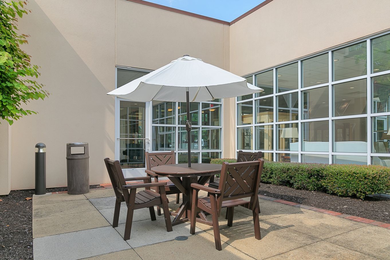 A patio with a table and chairs under an umbrella.
