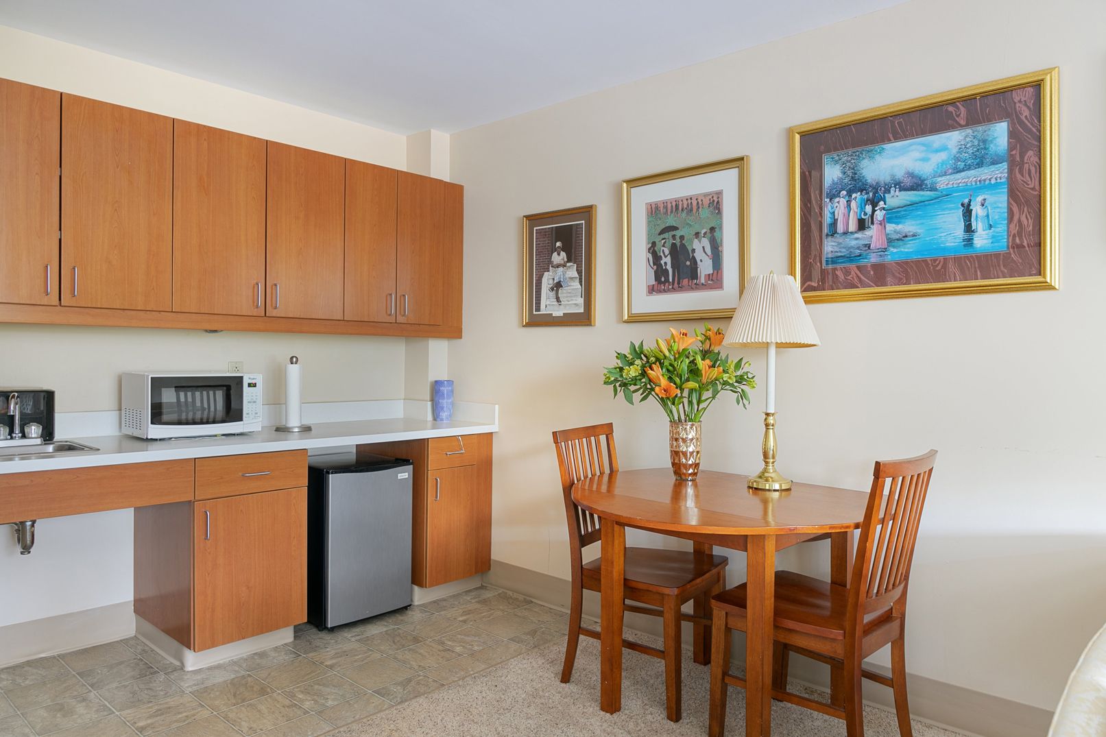 A kitchen with a table and chairs and a microwave