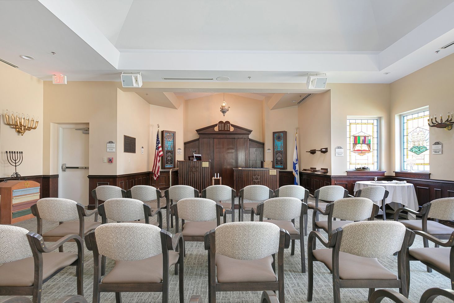 A room with rows of chairs and a table in it.