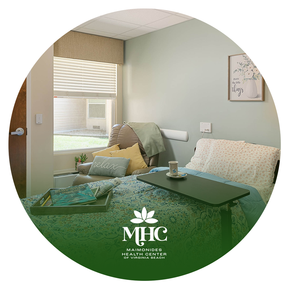 A hospital room with a bed , chair , table and window.