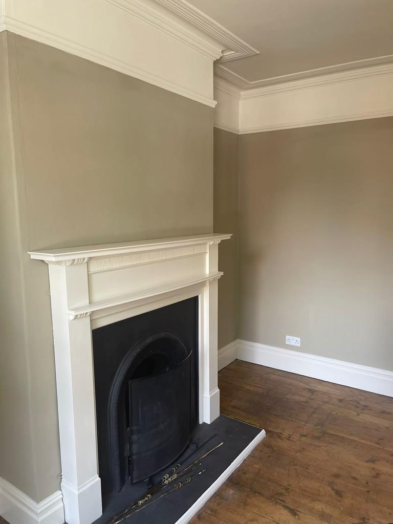 A picture of a feature wall fire place painted in sage green