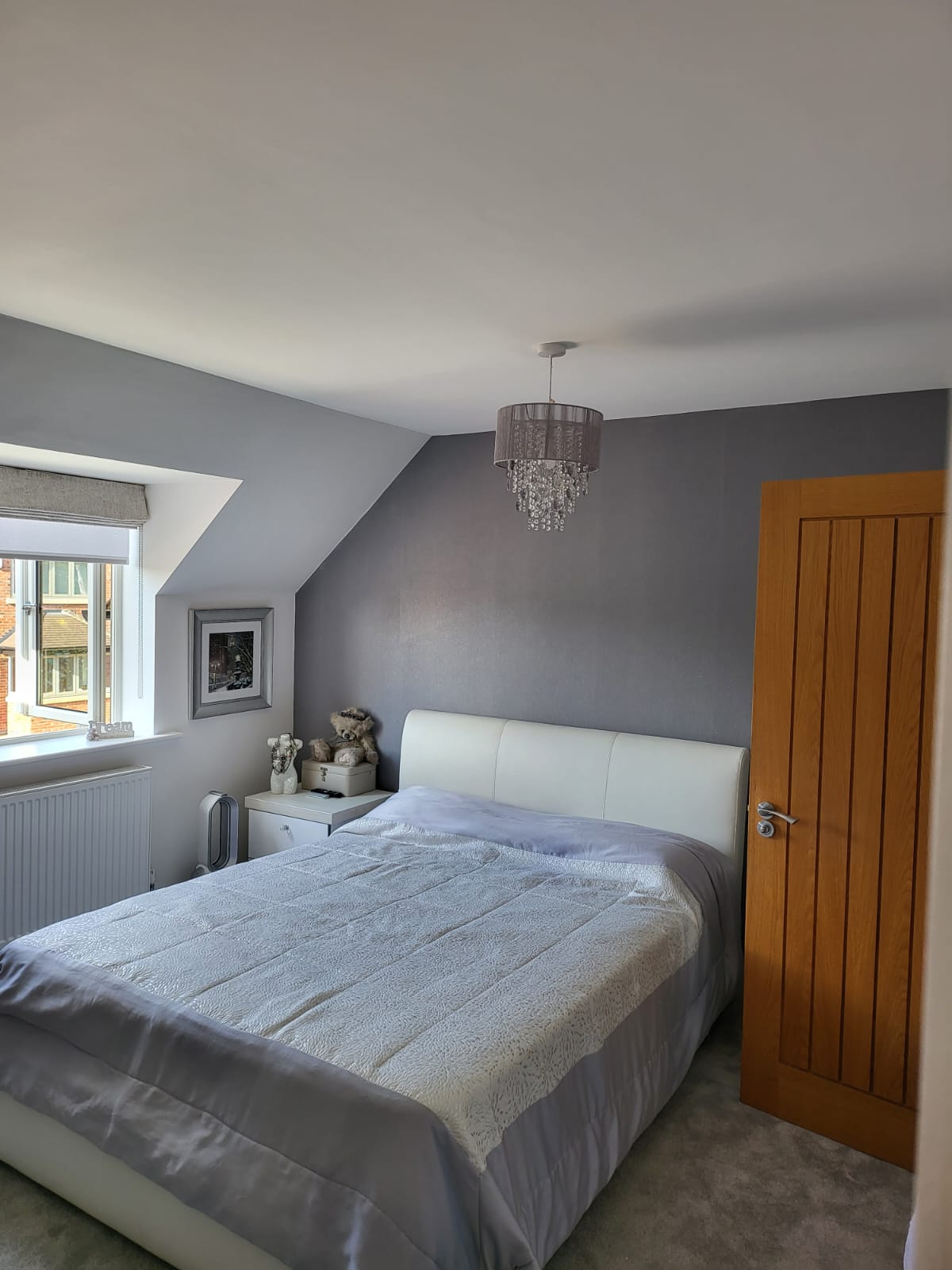 A picture of a bedroom attic room painted in grey by painters and decorators Derby