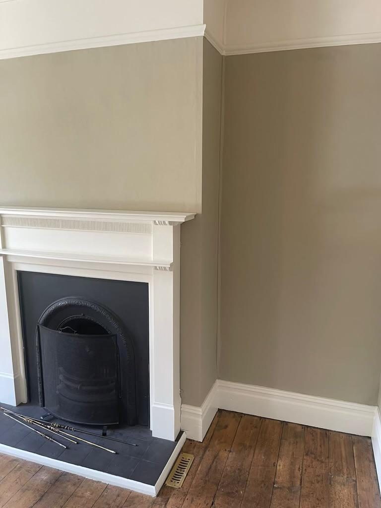 A picture of a feature fireplace painted in sage green by painters and decorators Derby