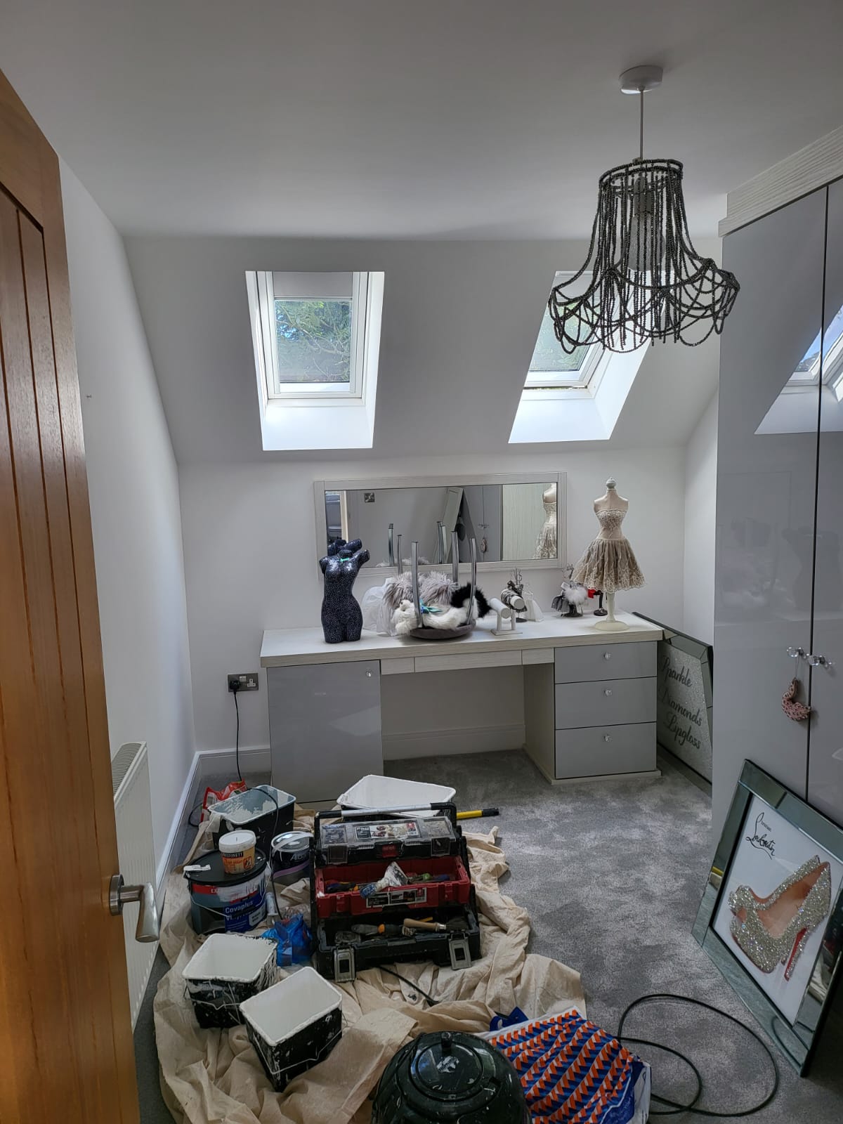 A picture of a walk in wardrobe painted in light grey and white by painters and decorators Derby