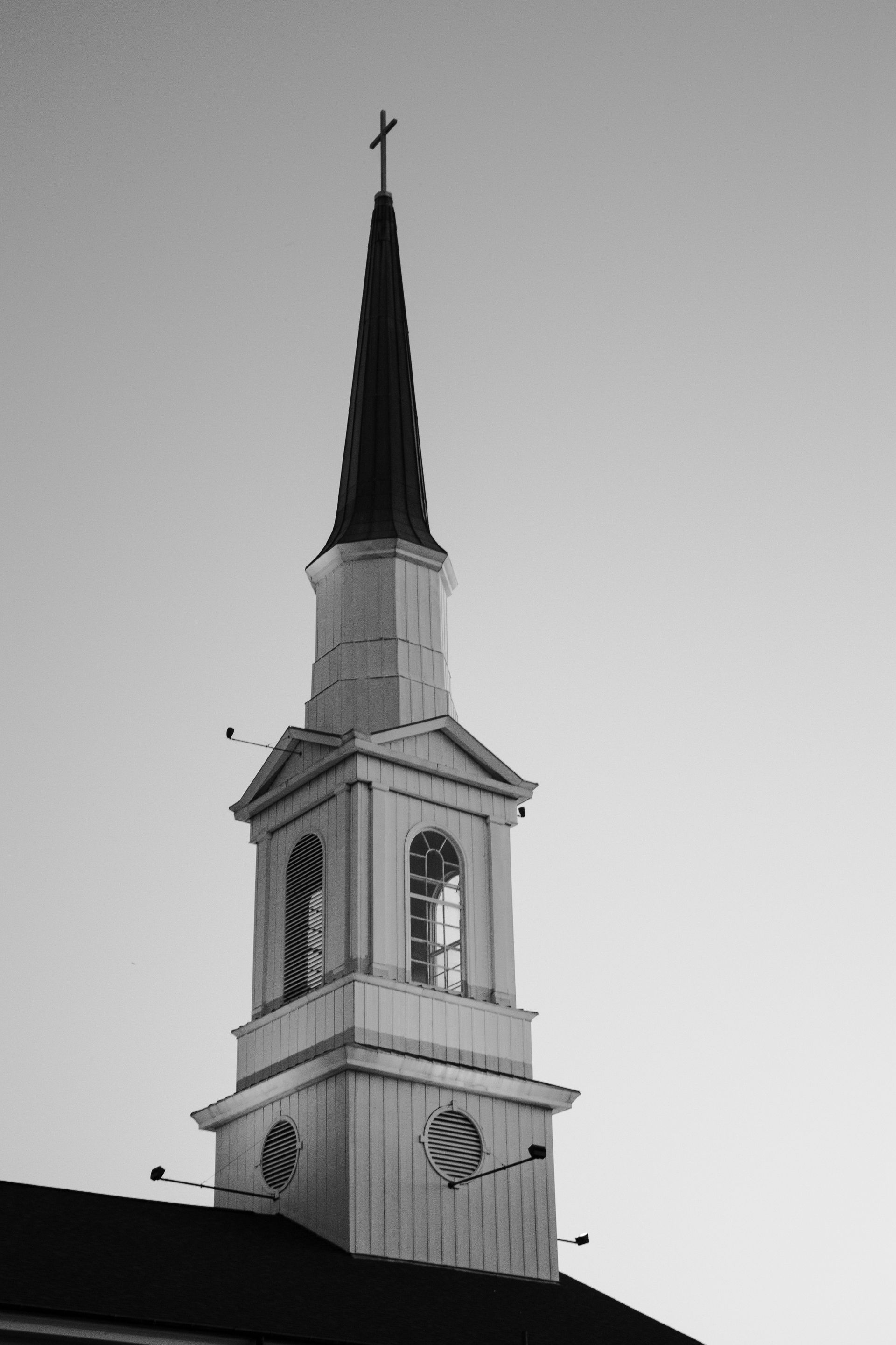 Church steeple with cross against a pale sky. Black and white photo. First Presbyterian Church, Lancaster, OH.