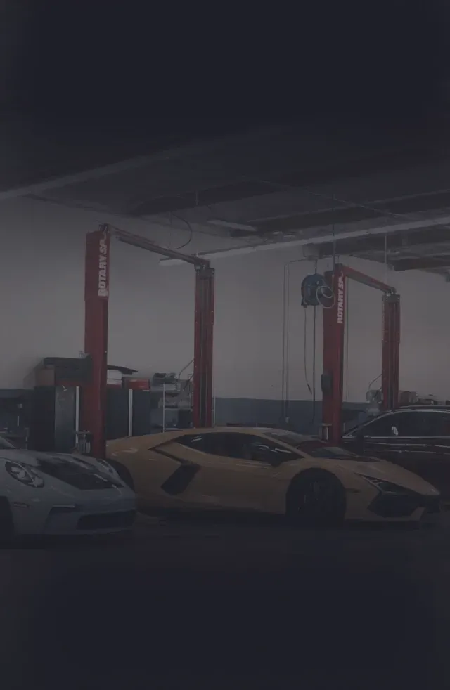 Row of cars in garage with dark overlay | Auto Squad OC