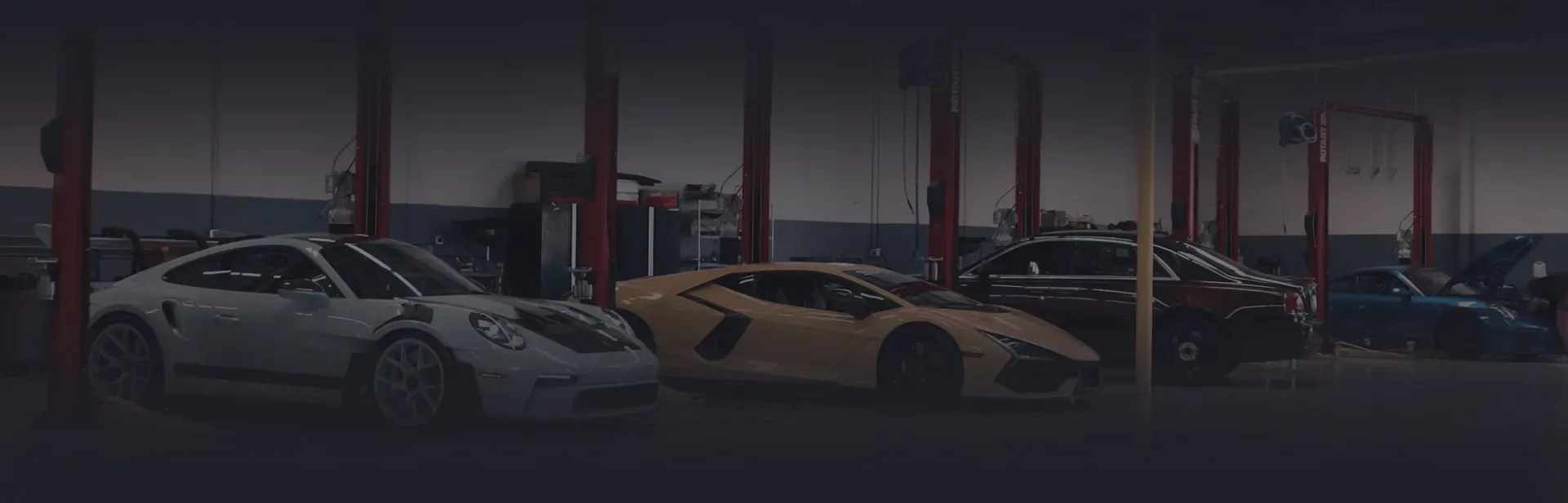 Row of cars in garage with dark overlay | Auto Squad OC