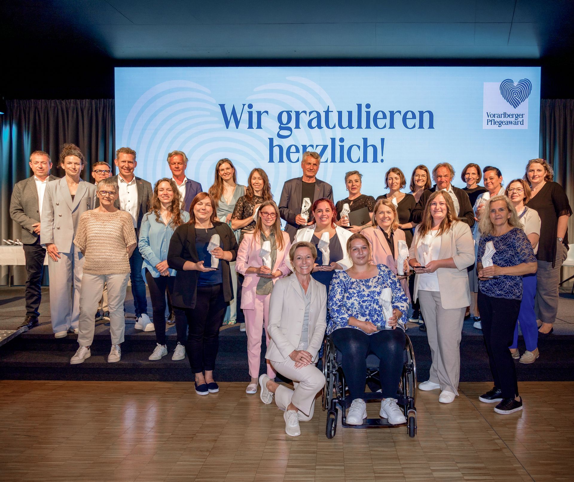 Gruppenbilder der Gewinner des Pflegeaward 2025 auf der Bühne.