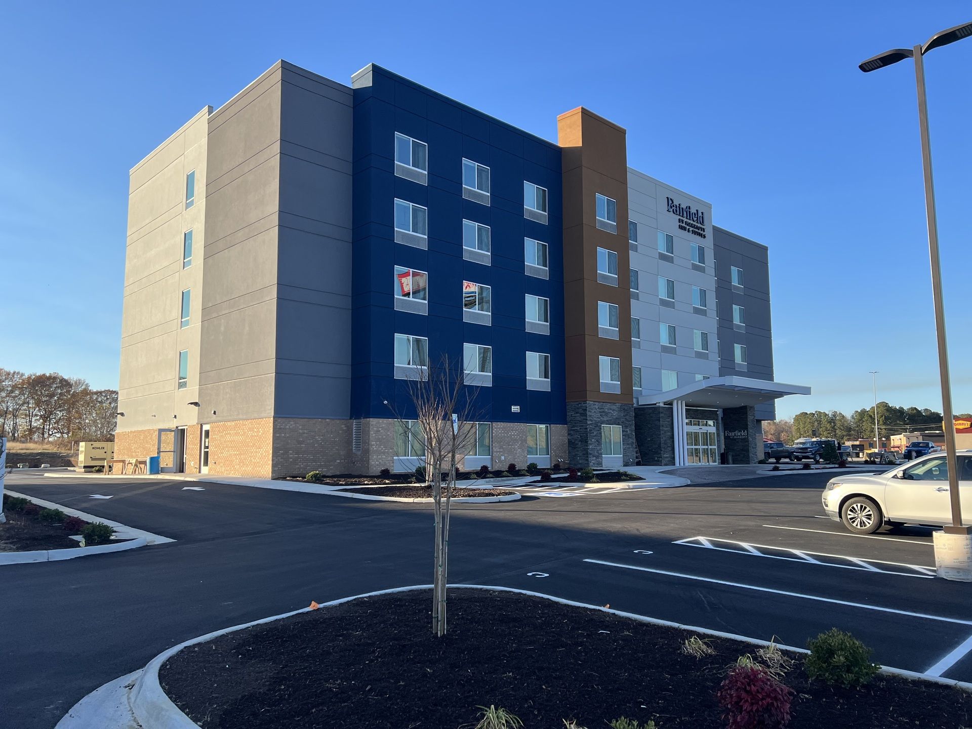 A large building with a lot of windows and a parking lot in front of it.