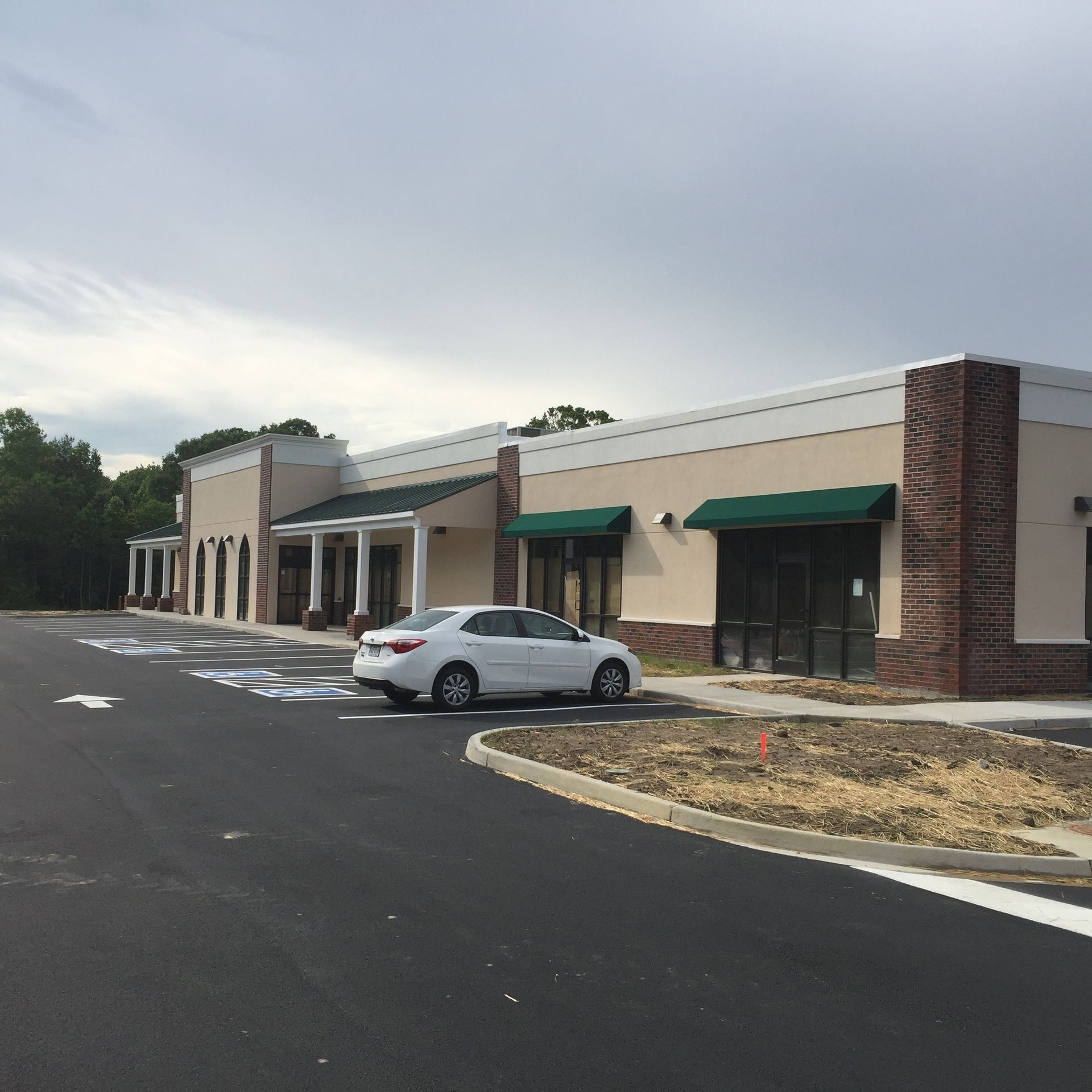 A white car is parked in front of a building