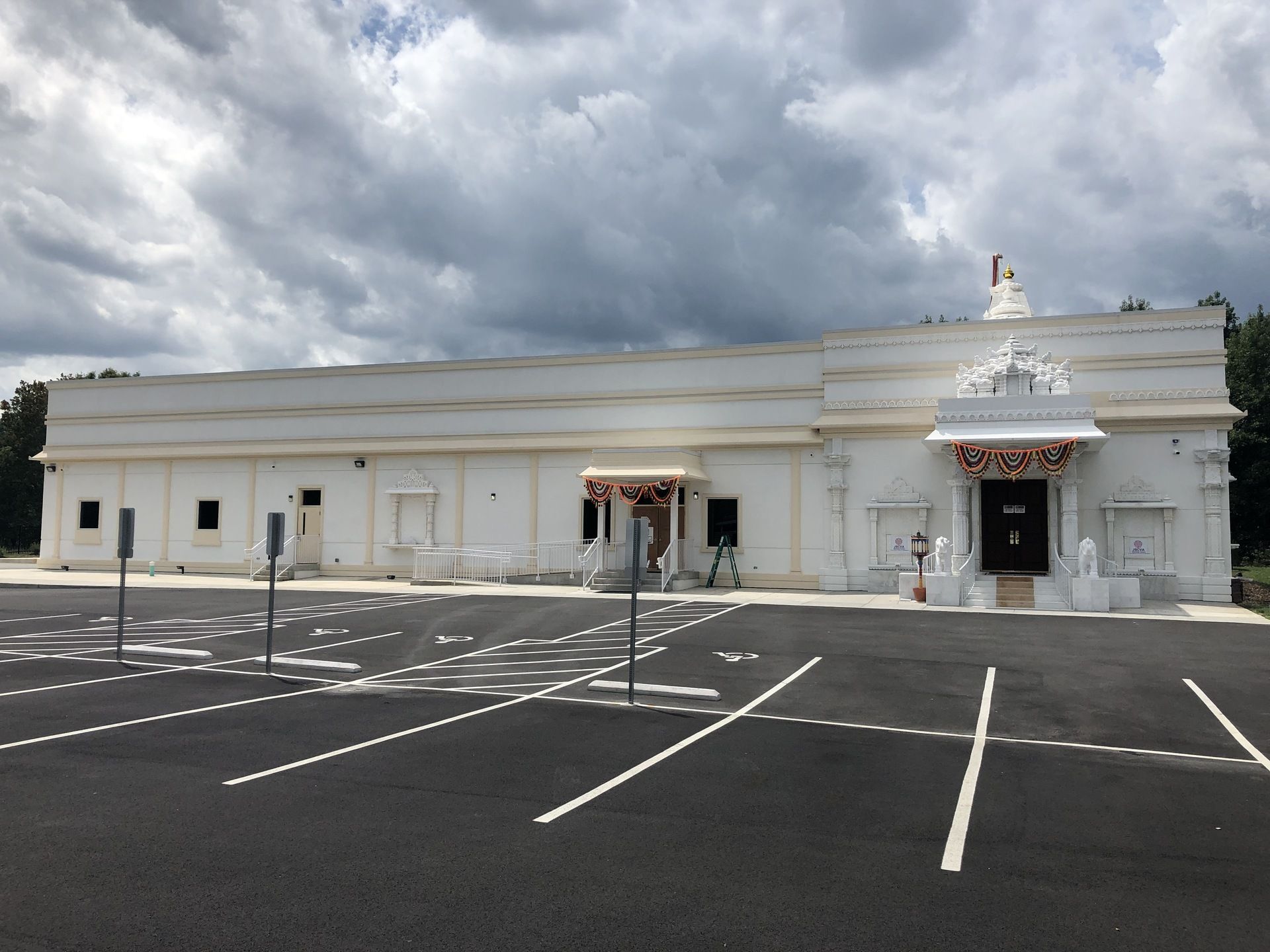 A large white building with a parking lot in front of it
