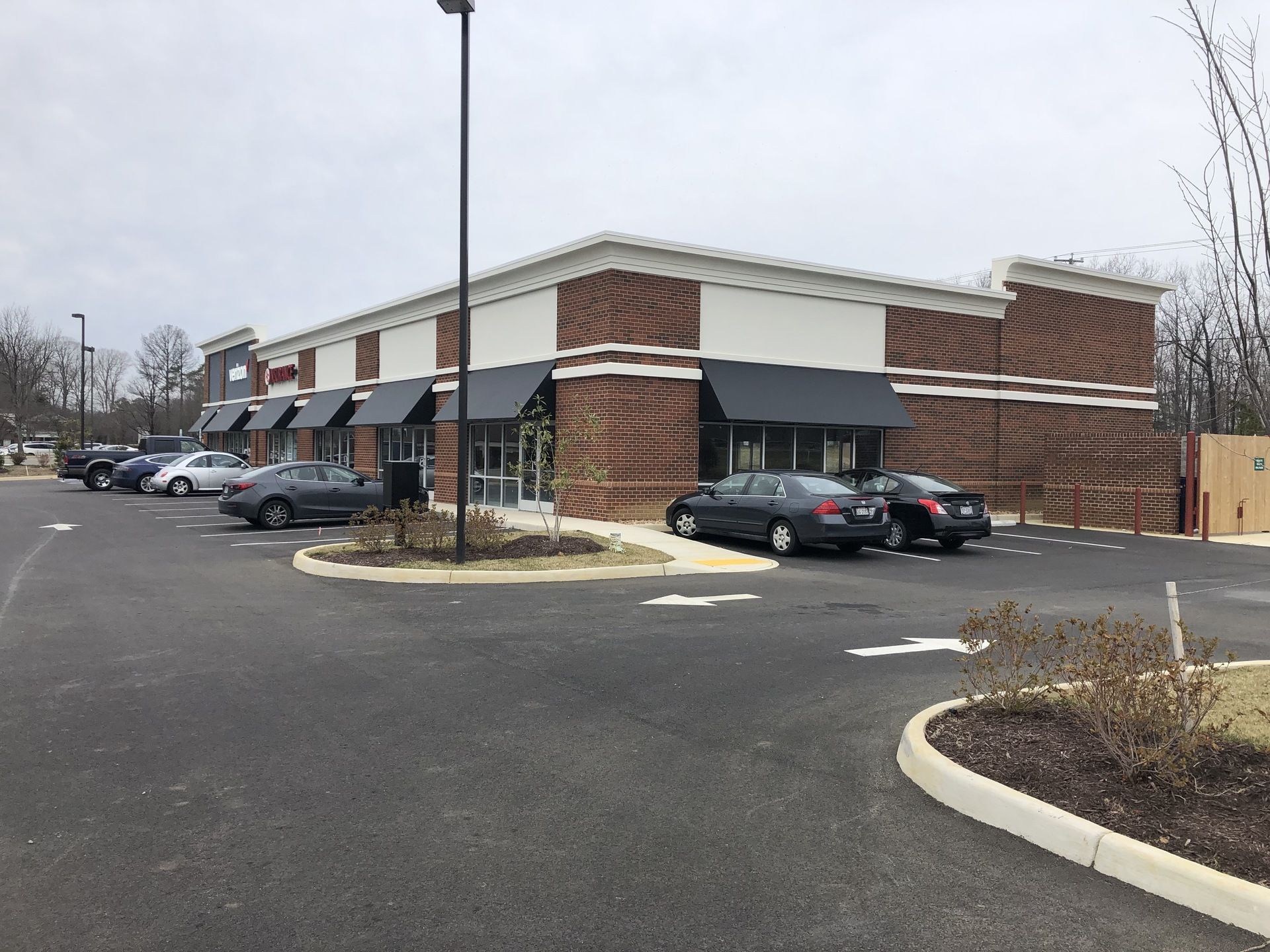 A parking lot with cars parked in front of a brick building.