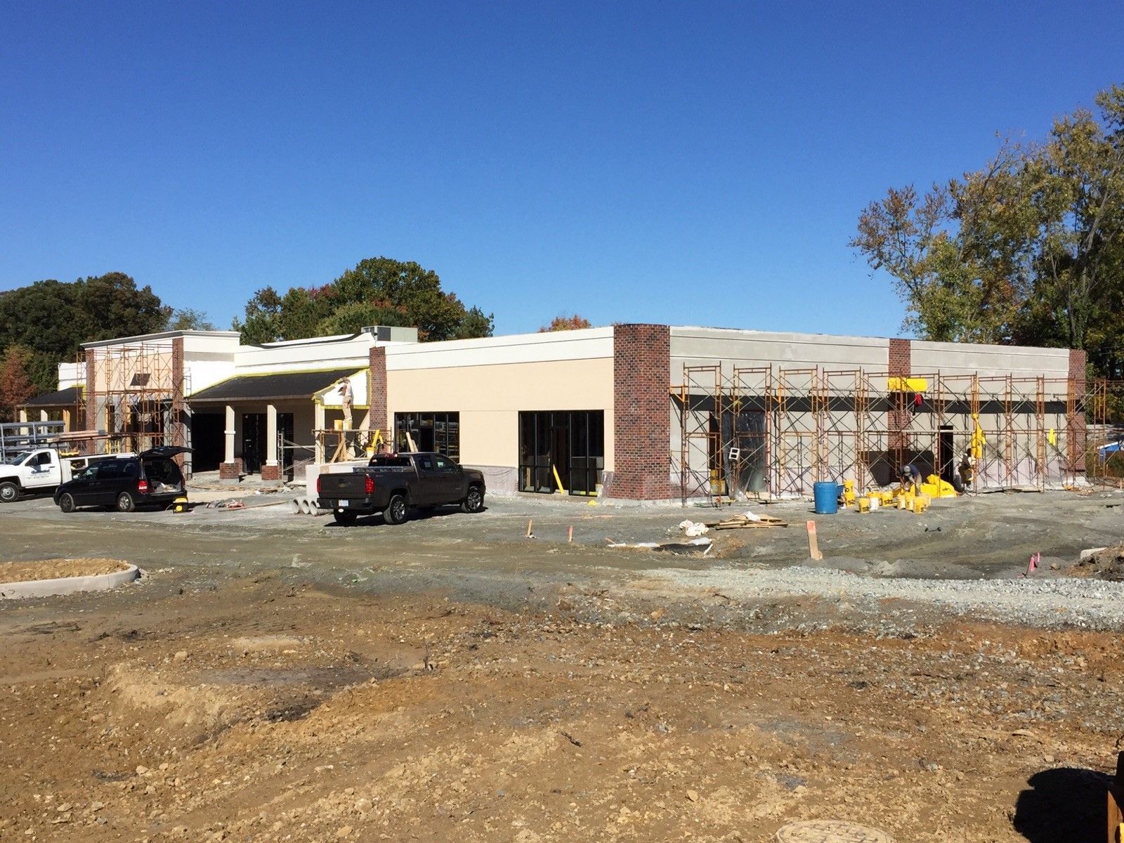 A truck is parked in front of a building under construction.
