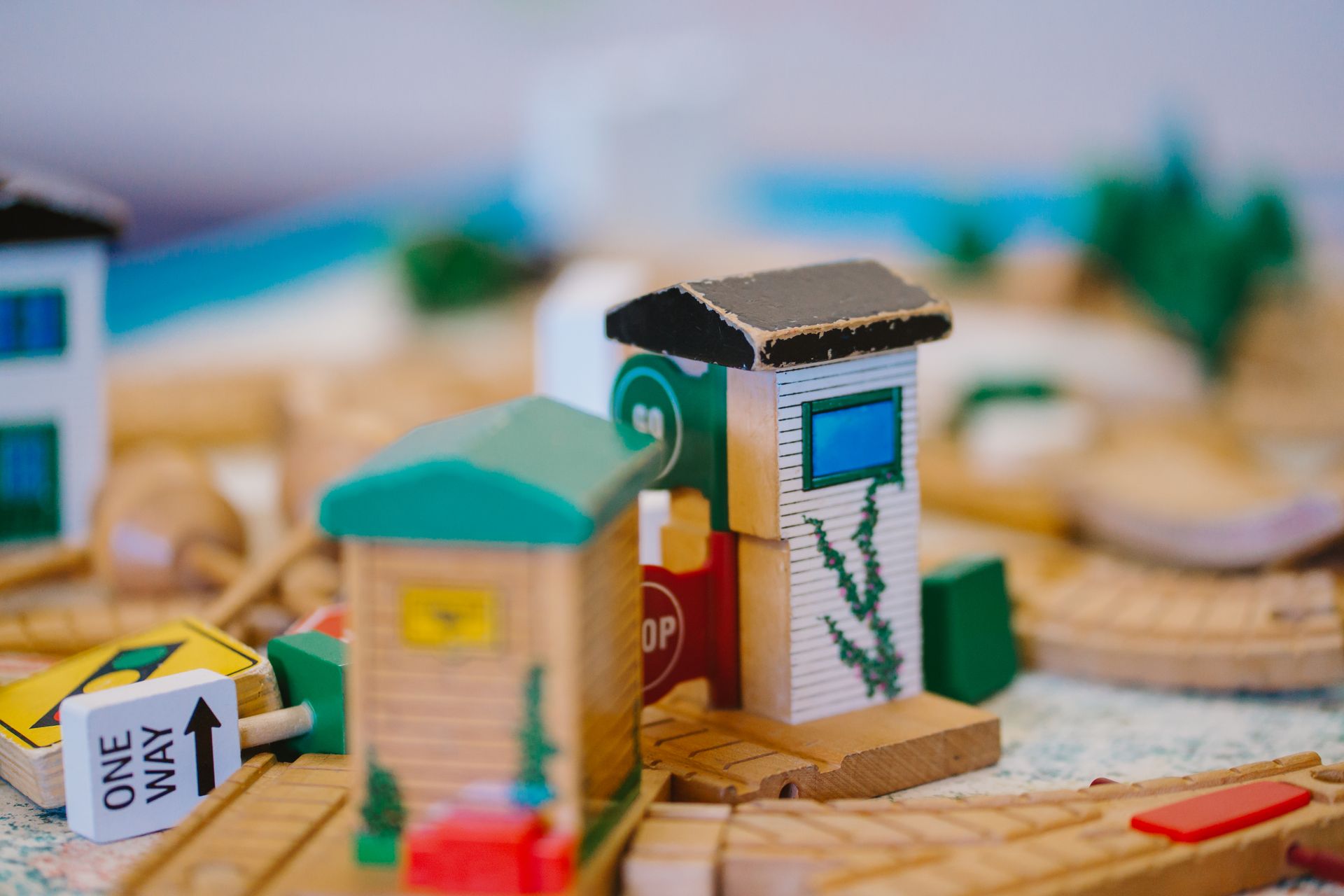 A wooden toy train set with a one way sign