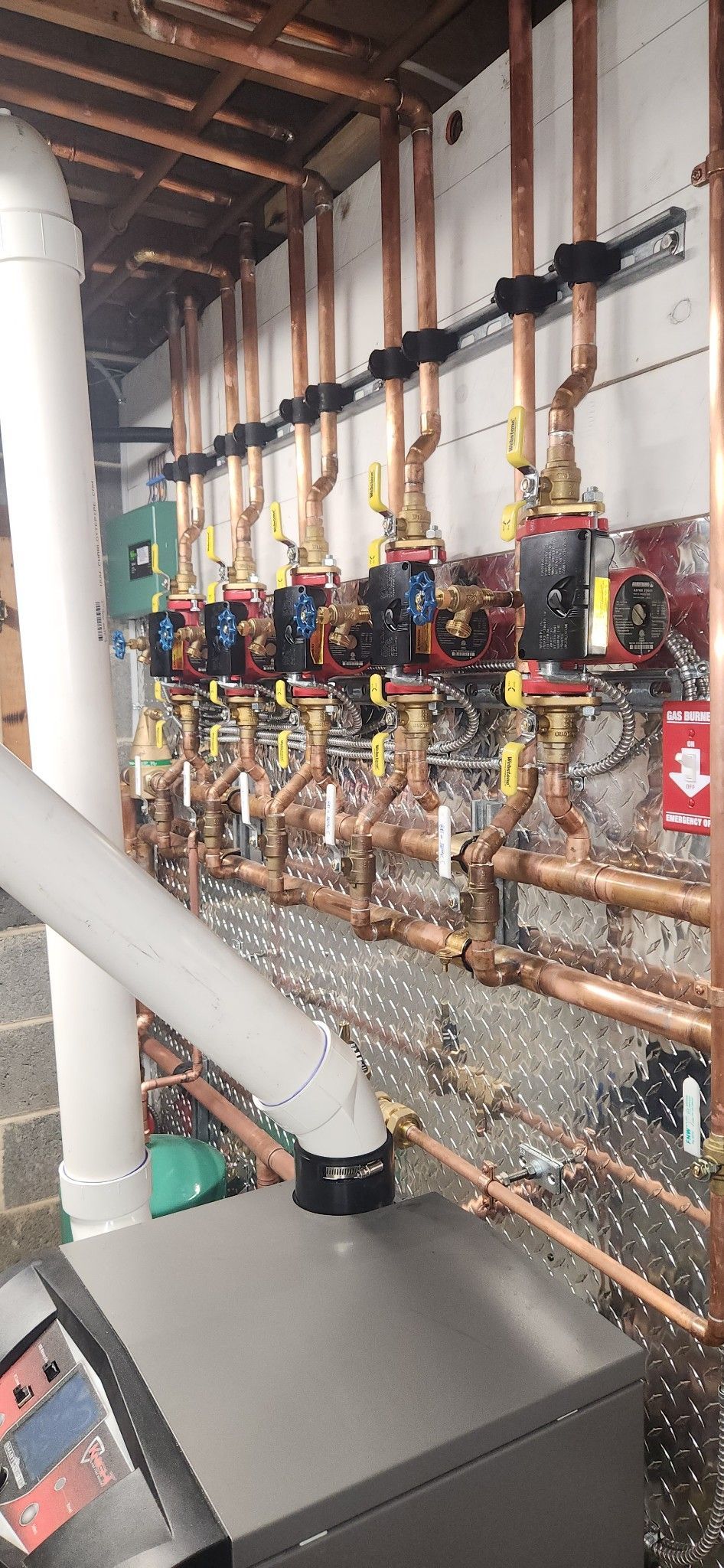 A room with a boiler and a water heater in it.