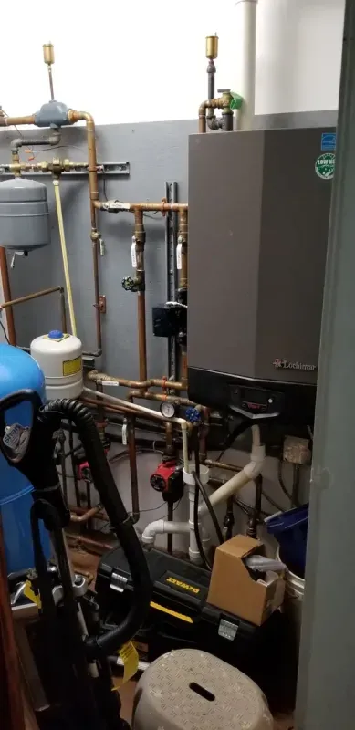 A room filled with lots of pipes and a vacuum cleaner.