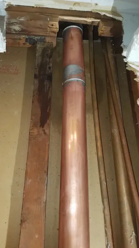 A close up of a copper pipe in a room.