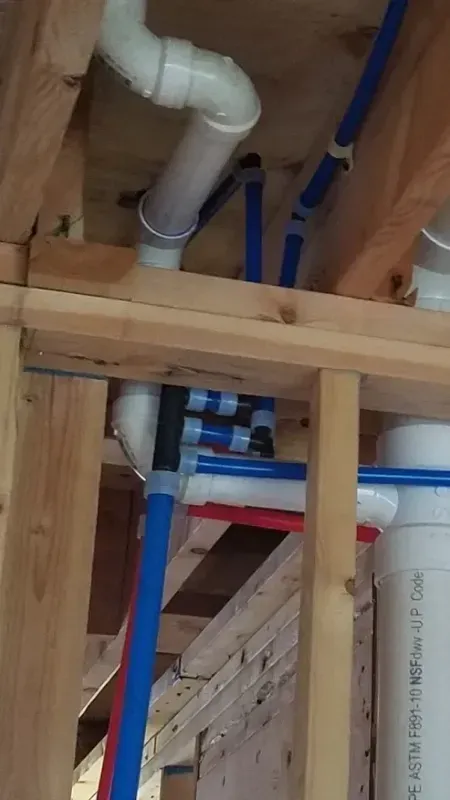 A bunch of pipes are hanging from the ceiling of a building.