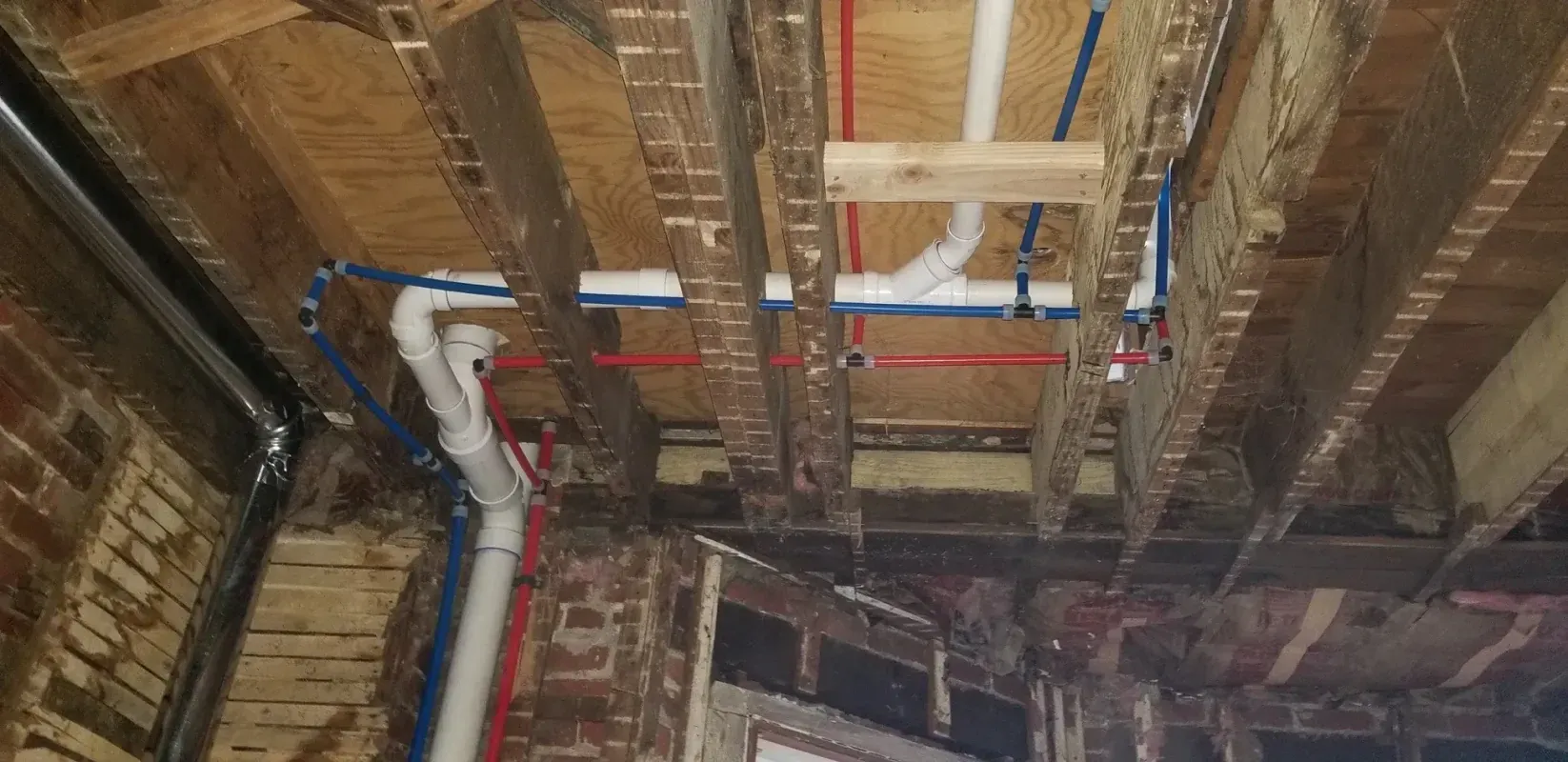 A bunch of pipes are hanging from the ceiling of a building.