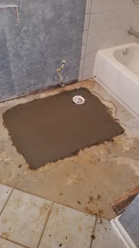 A shower stall is being built in a bathroom next to a bathtub.