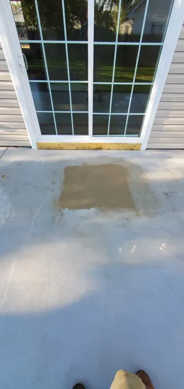 A person is standing in front of a sliding glass door.