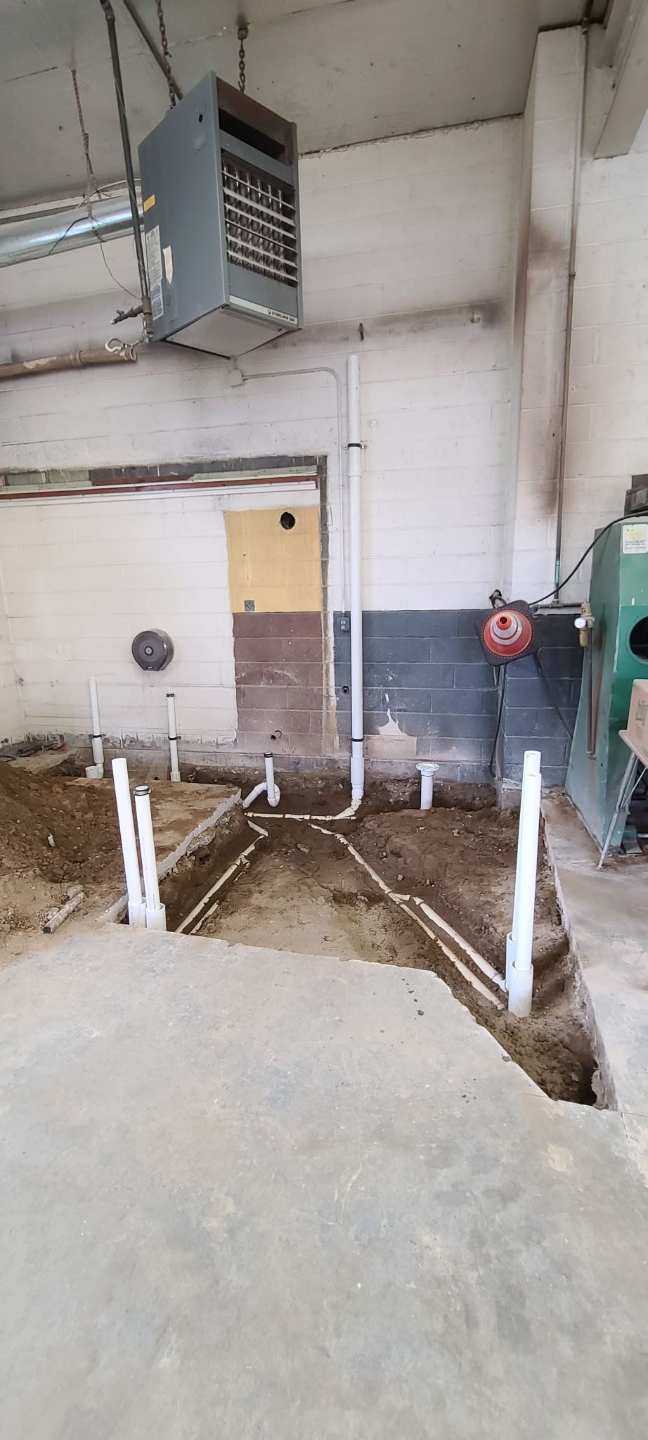 A house under construction with a lot of pipes coming out of the ceiling.